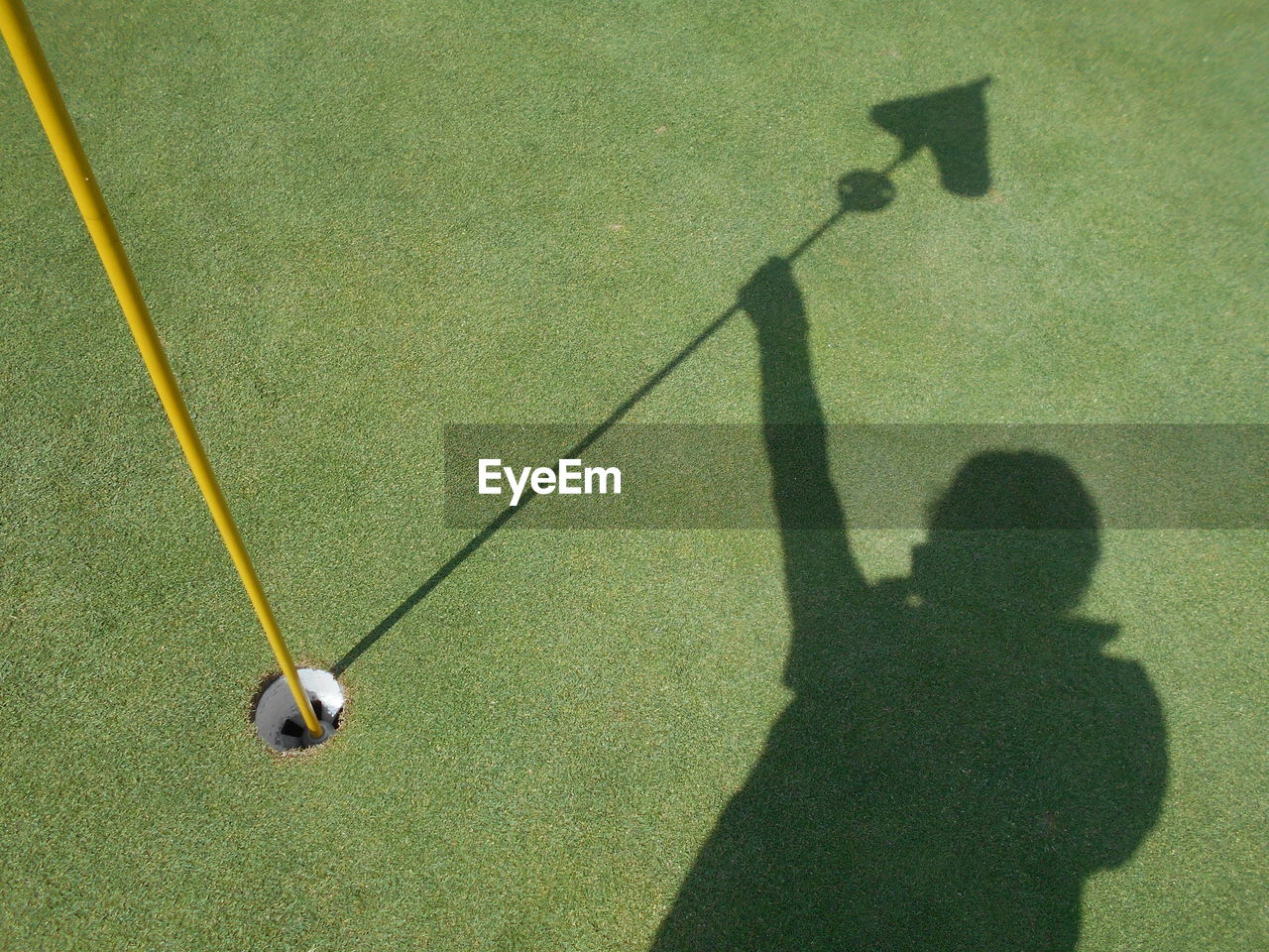 High angle view of shadow of man on golf course