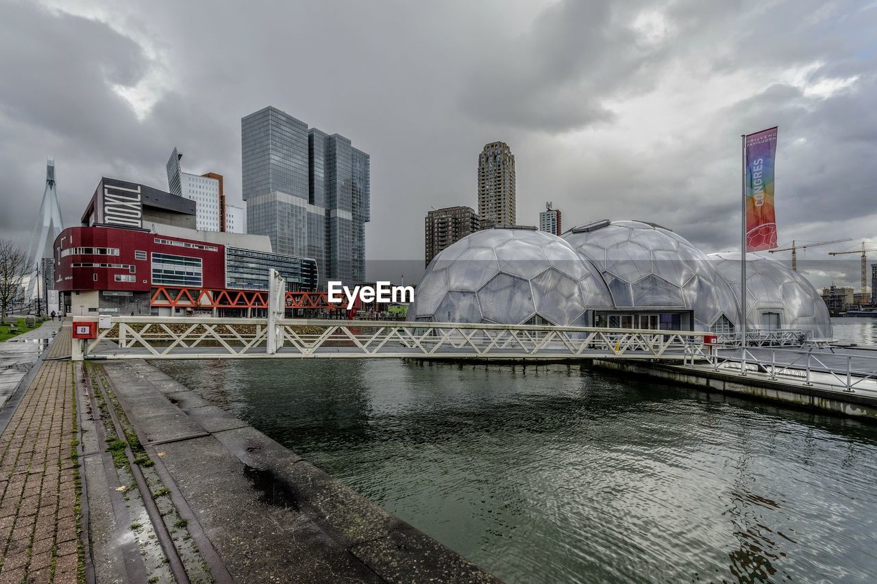 BRIDGE OVER RIVER AGAINST BUILDINGS IN CITY