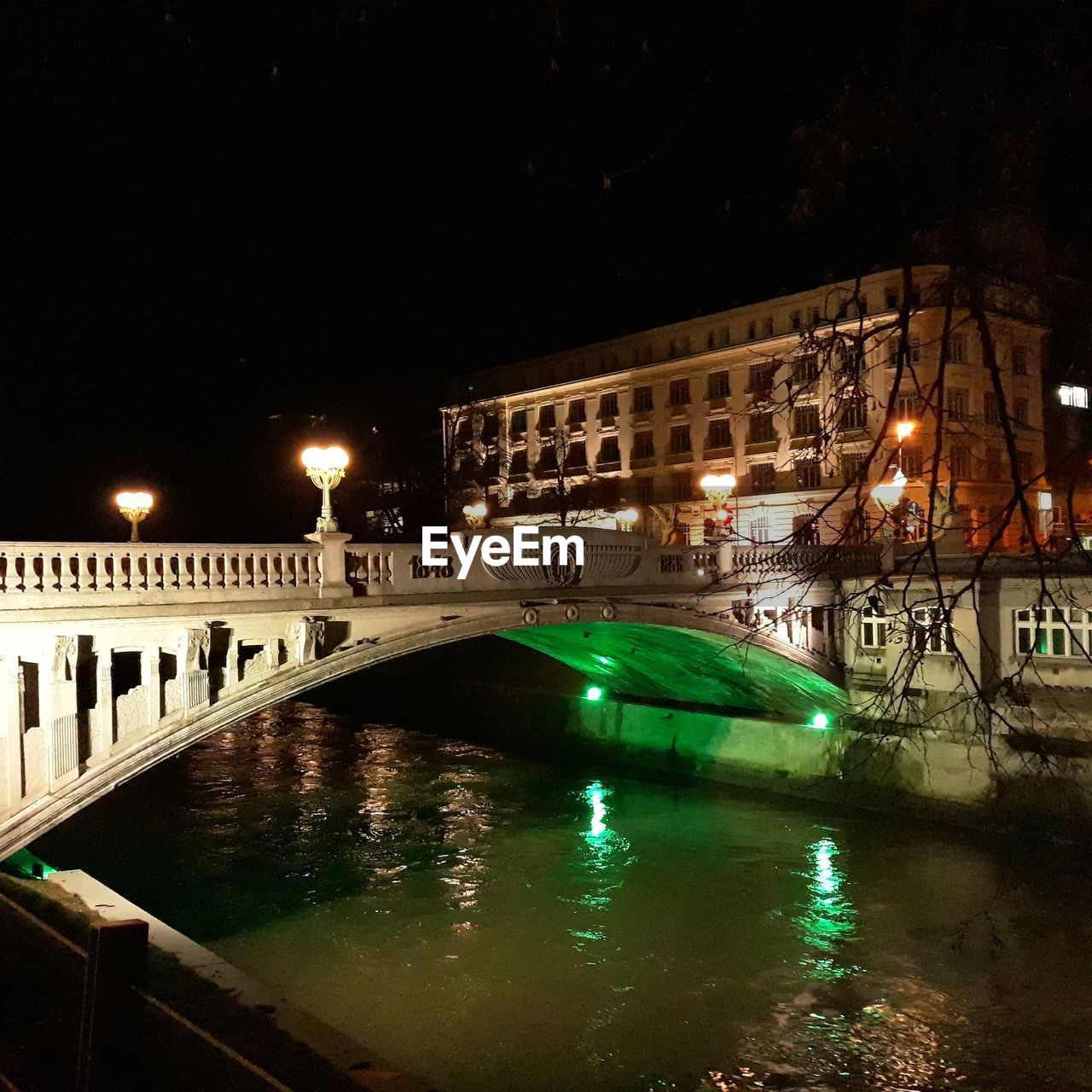 ILLUMINATED CITY BY WATER AT NIGHT