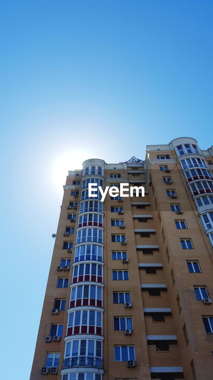 LOW ANGLE VIEW OF RESIDENTIAL BUILDINGS AGAINST CLEAR BLUE SKY