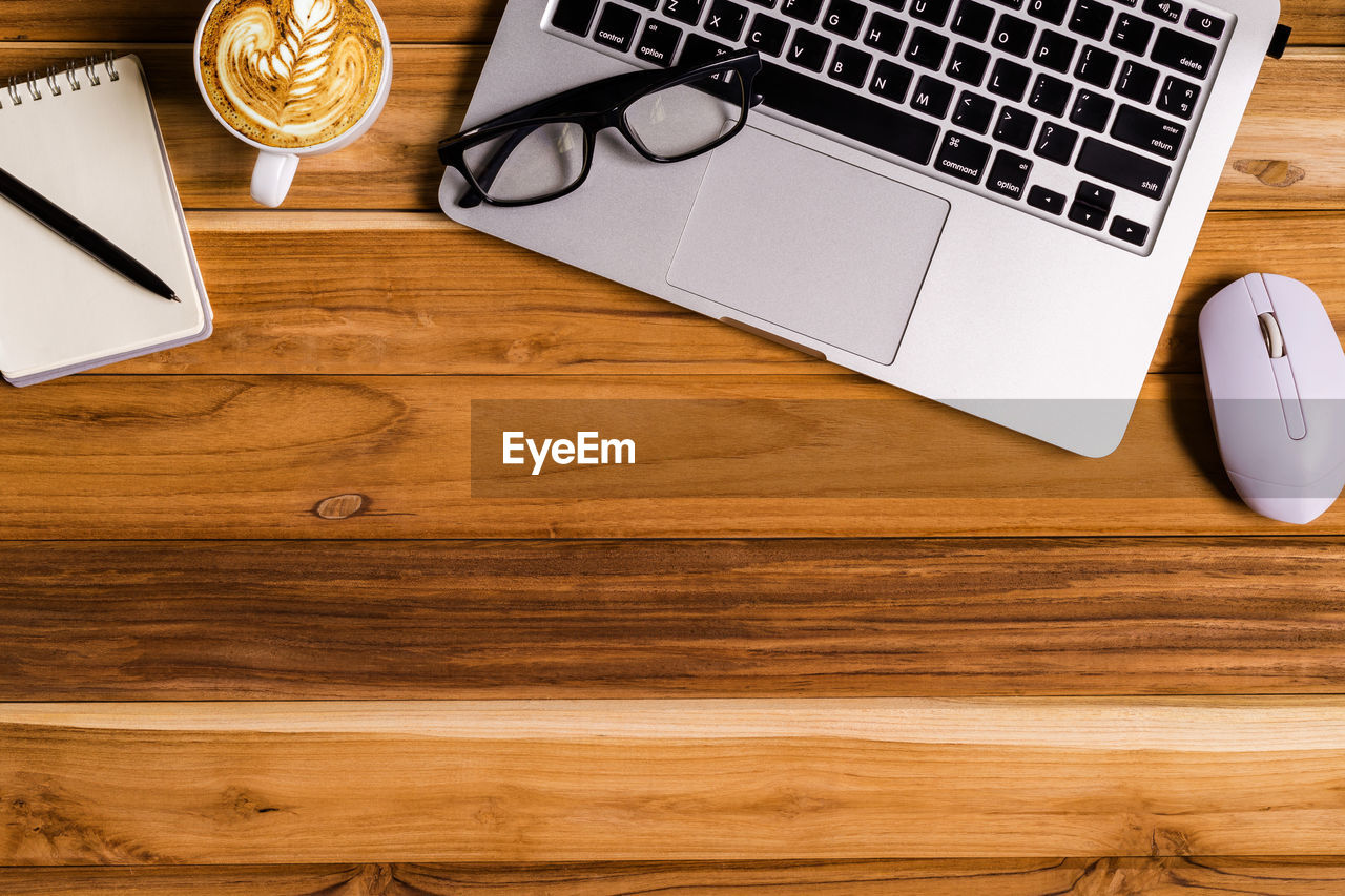 High angle view of laptop with coffee and eyeglasses on table