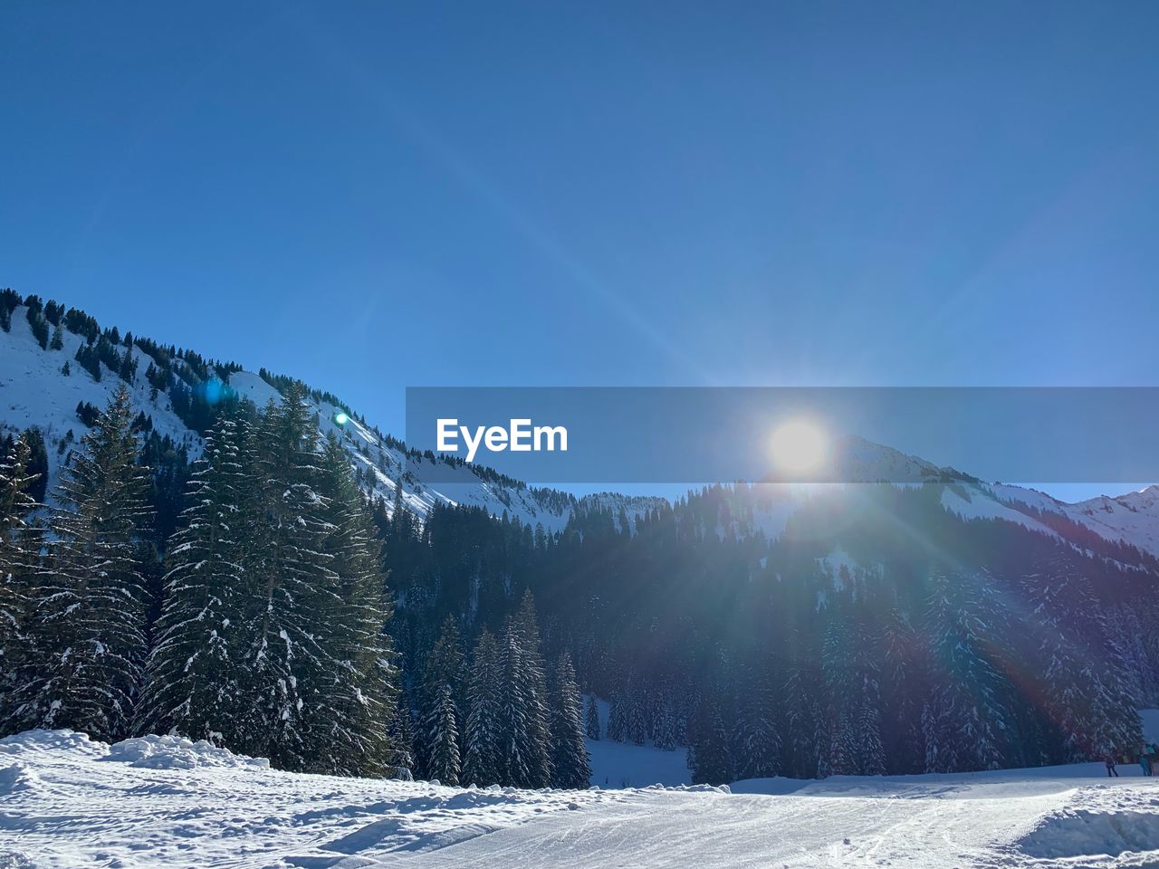 Scenic view of snowcapped mountains against blue sky