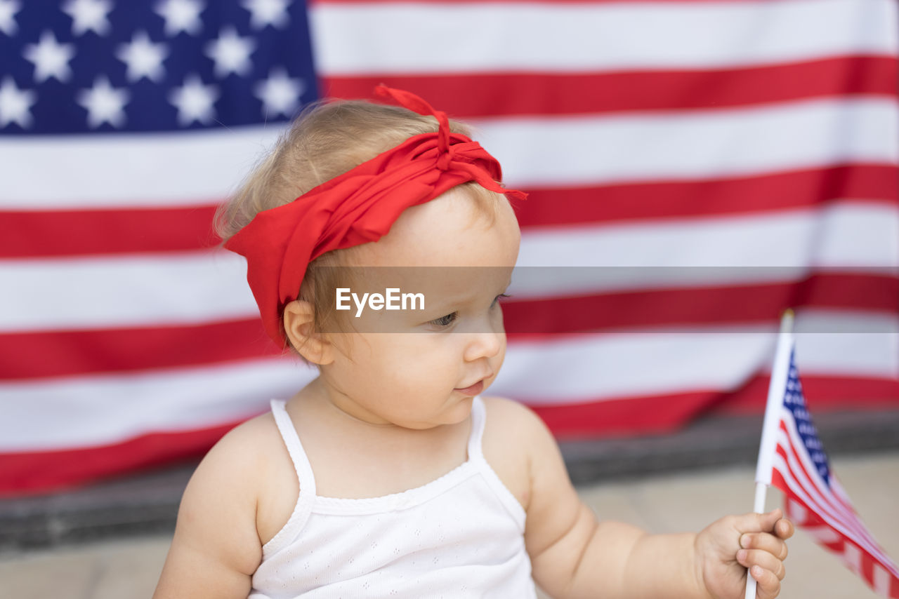 close-up of cute baby girl holding american flag