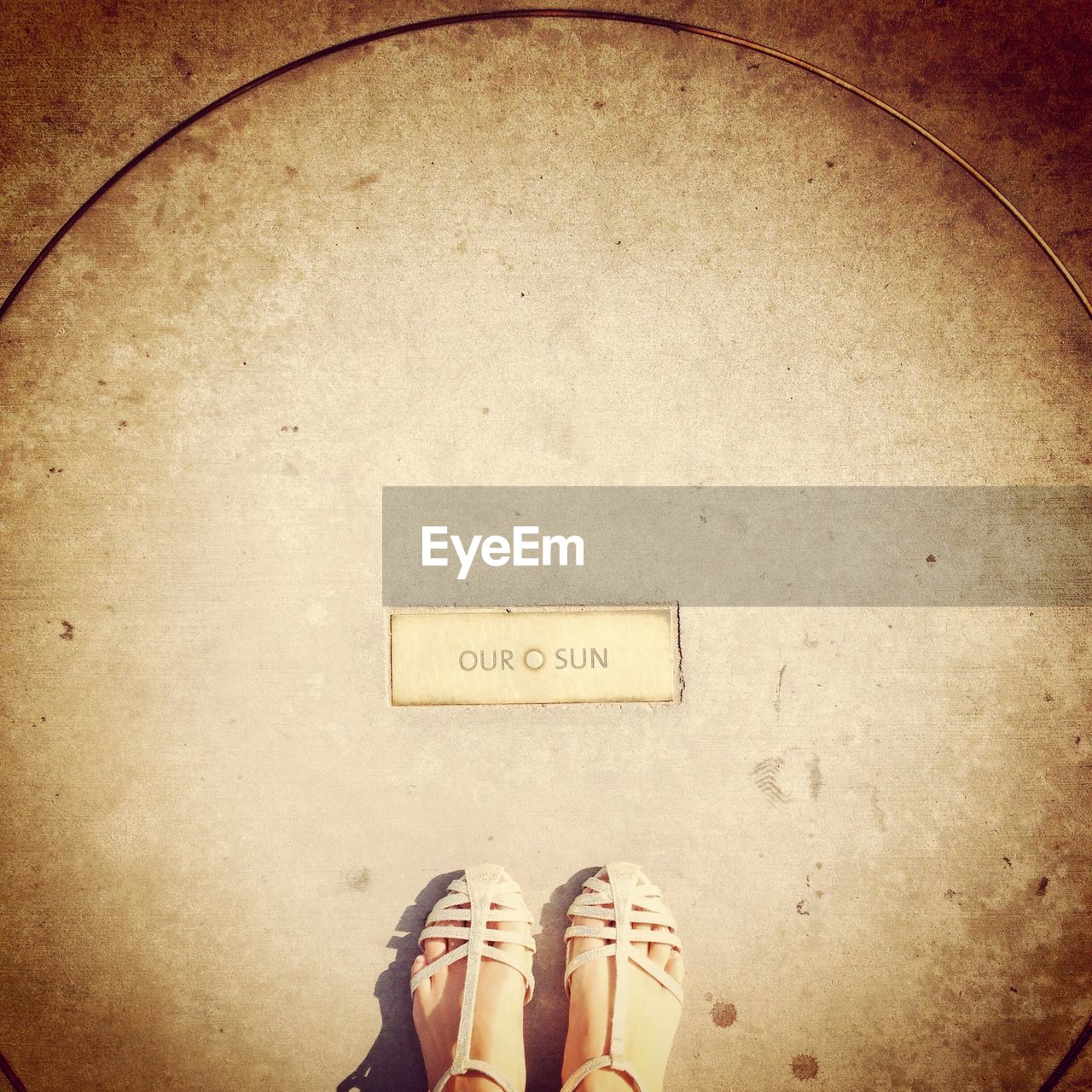 Low section of woman standing in front of text written on floor