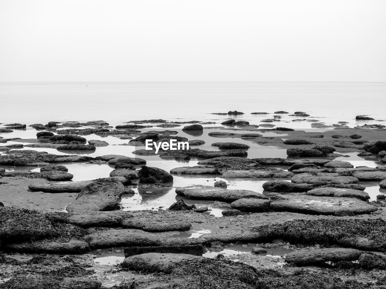Rocks on beach against clear sky