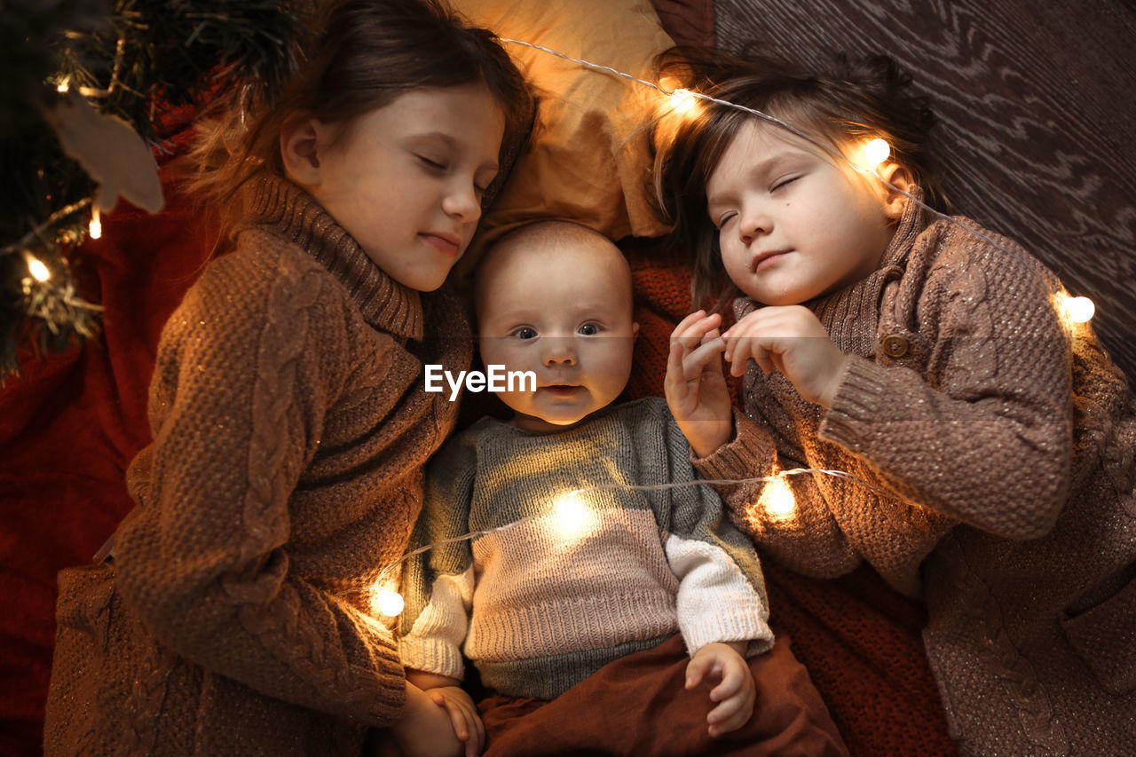 Funny children sleep together and embrace in a dark cozy interior, 