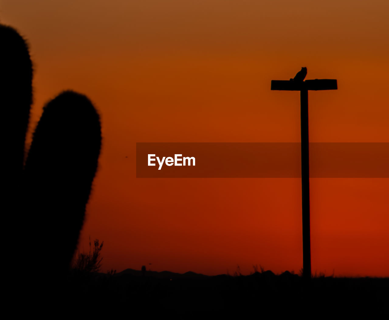 SILHOUETTE CROSS AGAINST ORANGE SKY DURING SUNSET