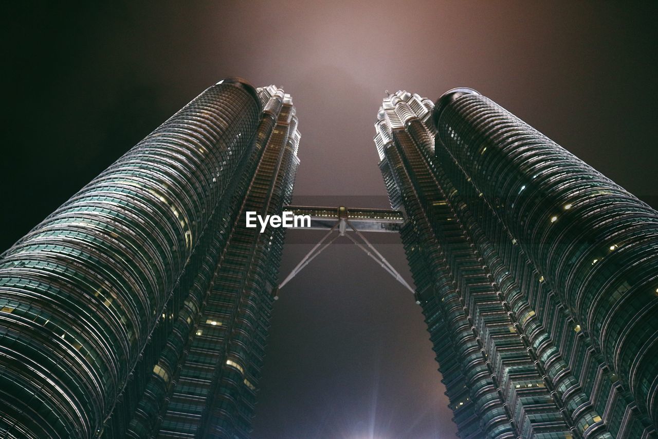 Low angle view of illuminated buildings against sky at night