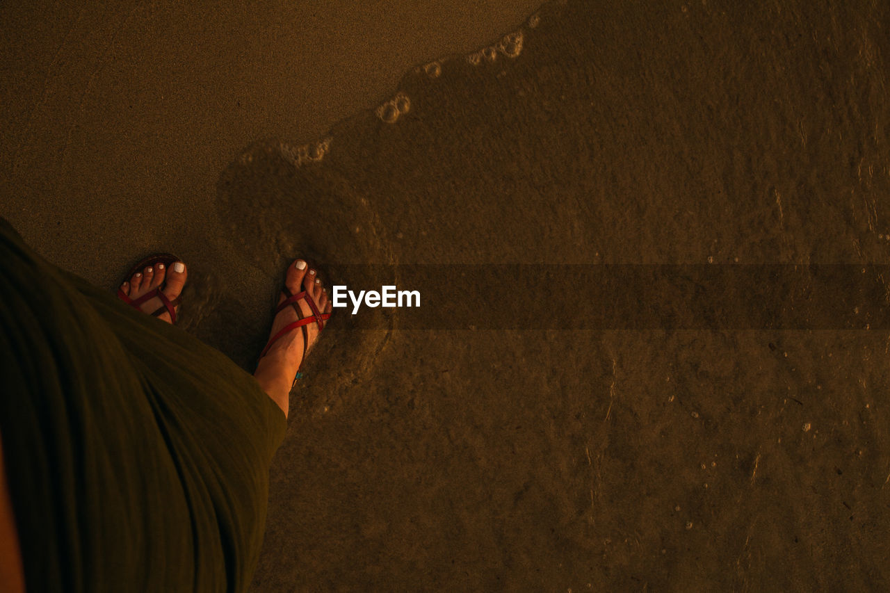 LOW SECTION OF WOMAN ON BEACH