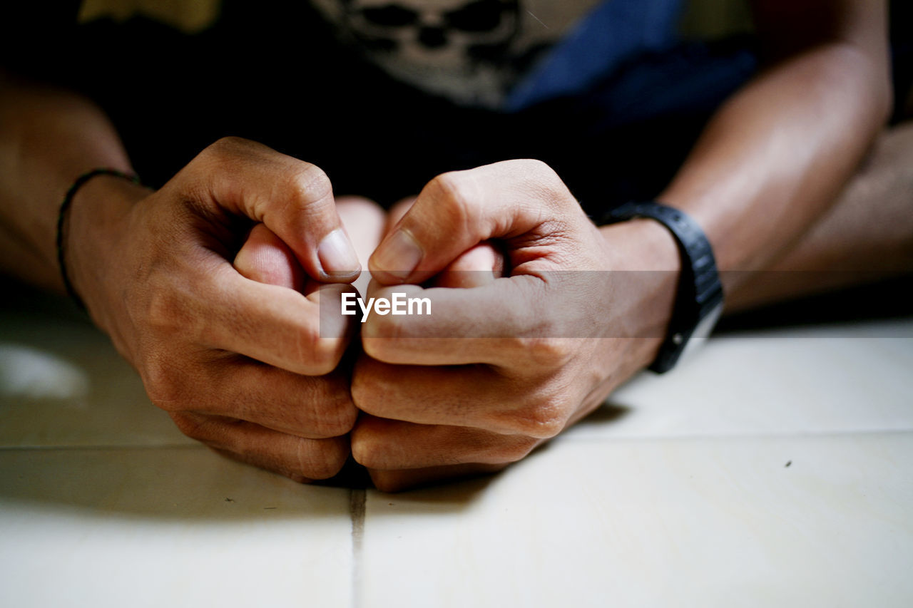 Close-up of cropped hands holding person foot on floor