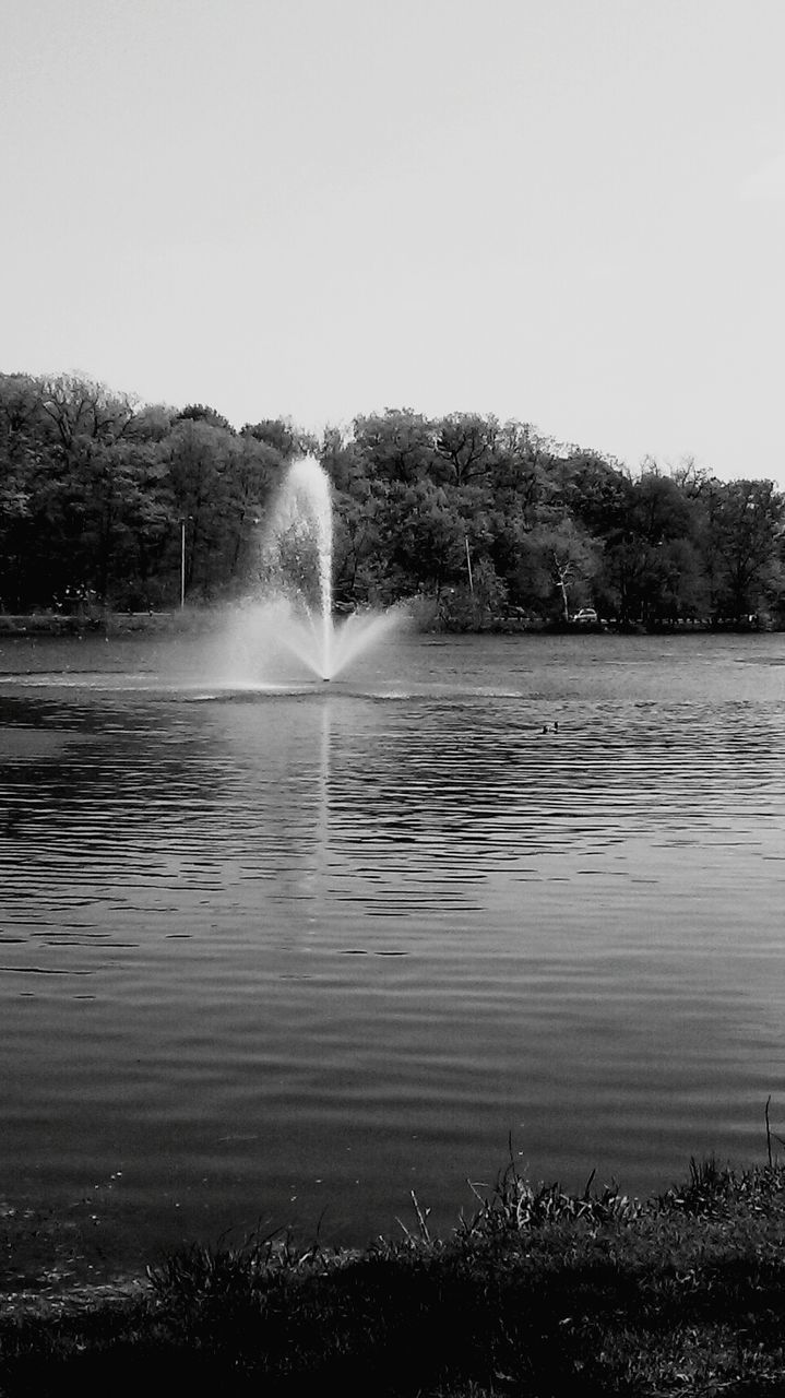 Water fountain amidst lake against sky