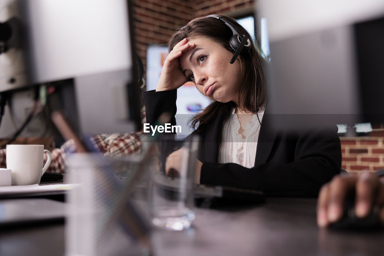 young woman looking away while sitting in cafe