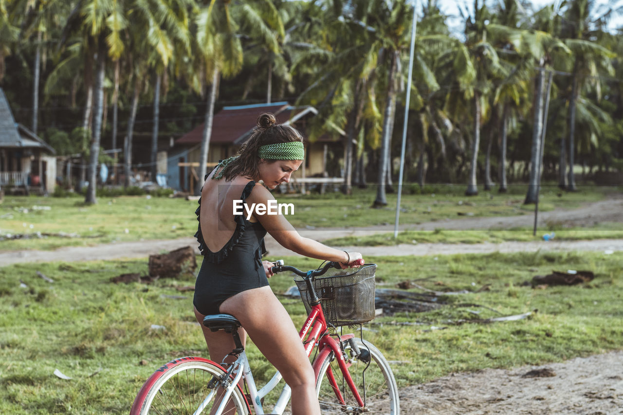 Young woman riding bicycle on field