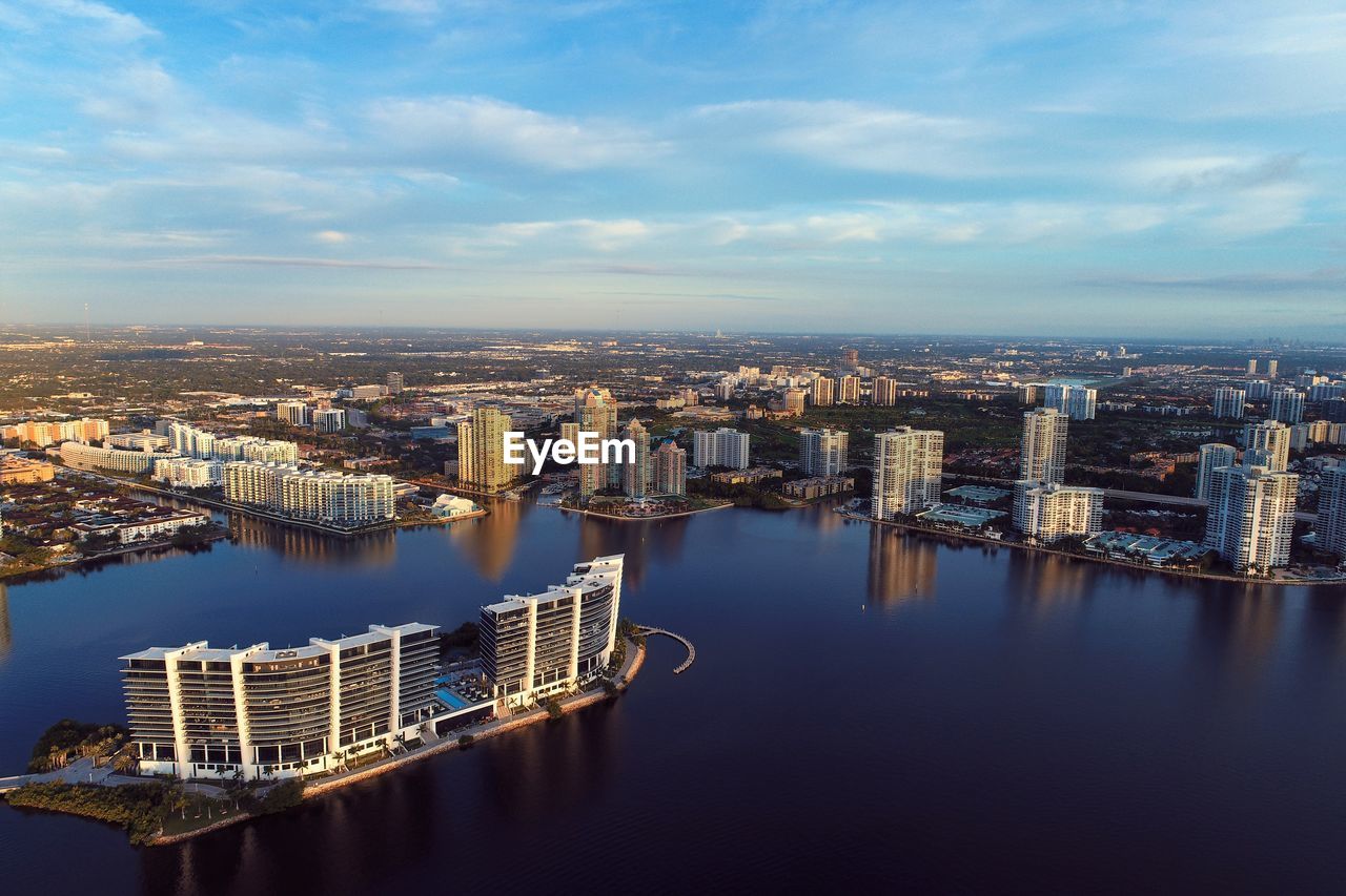 High angle view of buildings by river against sky