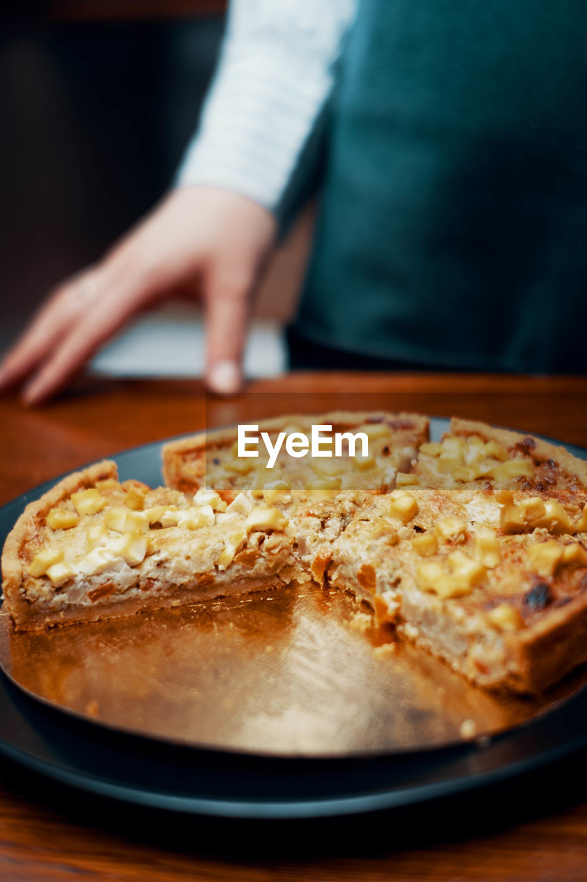 CLOSE-UP OF HAND WITH BREAD IN PLATE