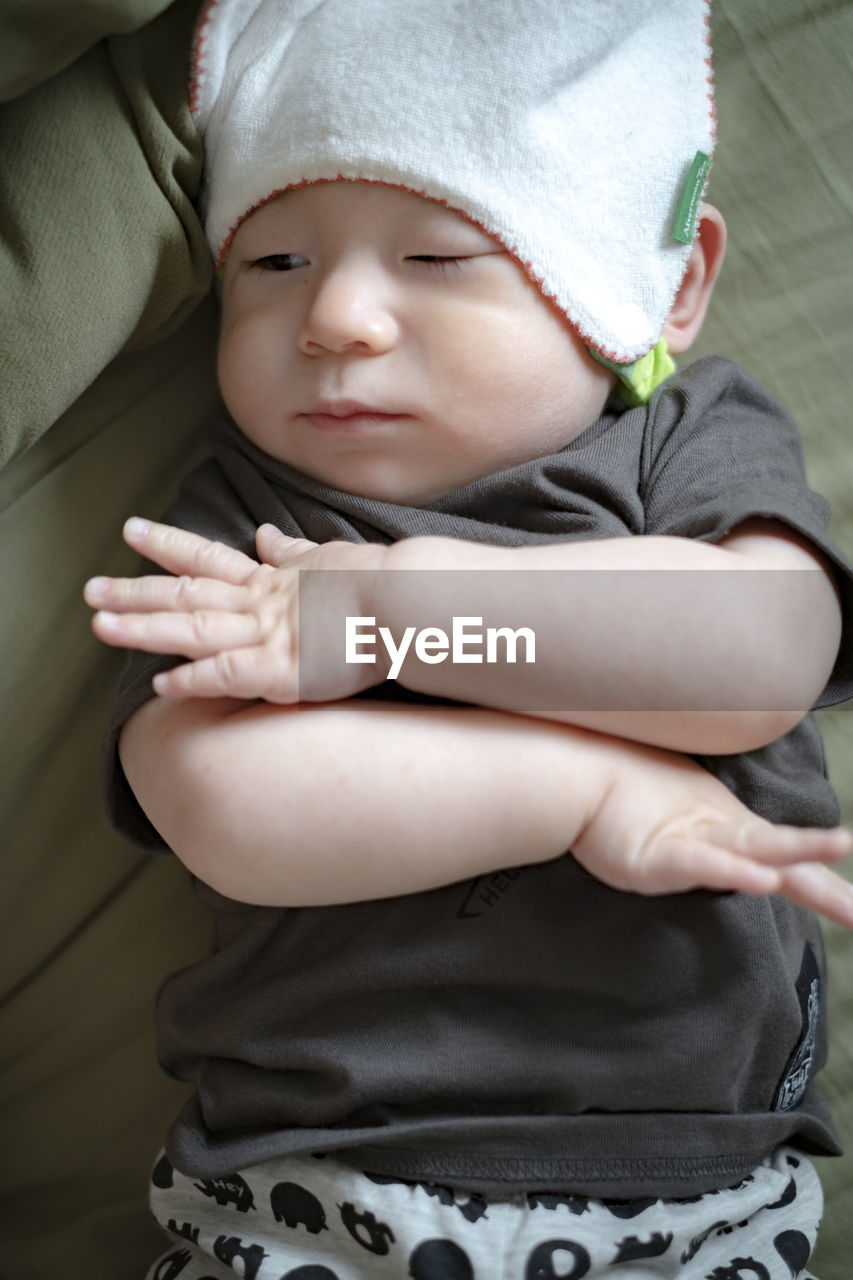 High anlge portrait of cute baby lying on bed at home