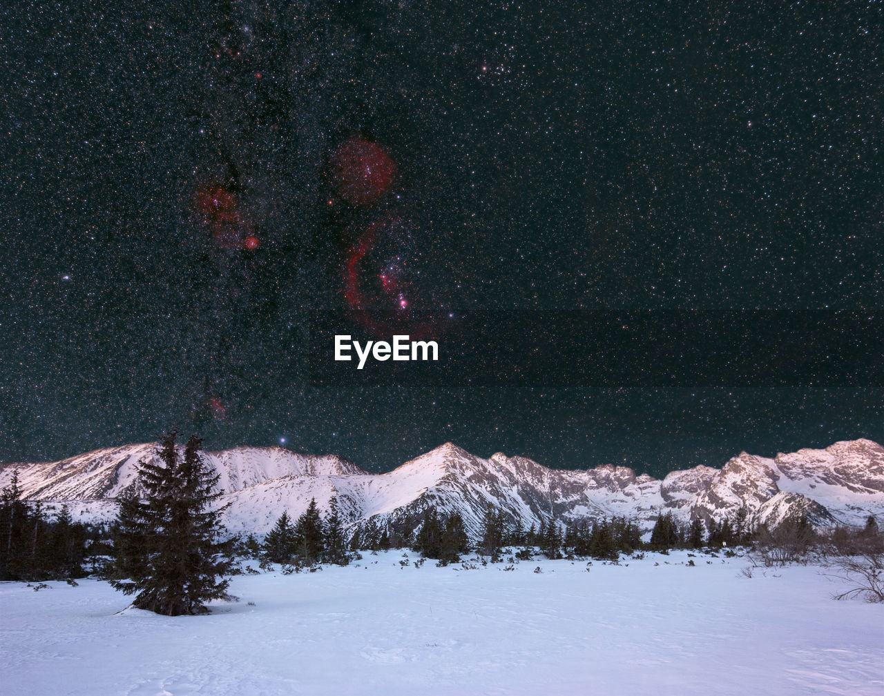 Scenic view of snowcapped mountains against sky at night