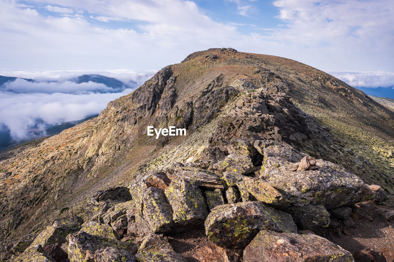 SCENIC VIEW OF MOUNTAINS AGAINST CLOUDY SKY