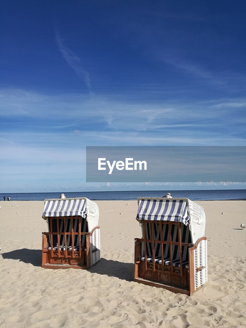 CHAIRS AT BEACH AGAINST SKY