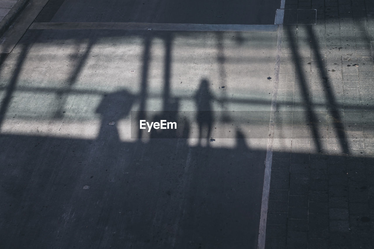 Shadow of people on street in city