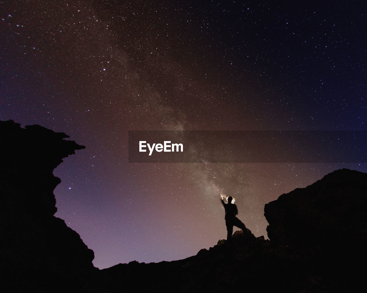 Low angle view of silhouette man against sky at night