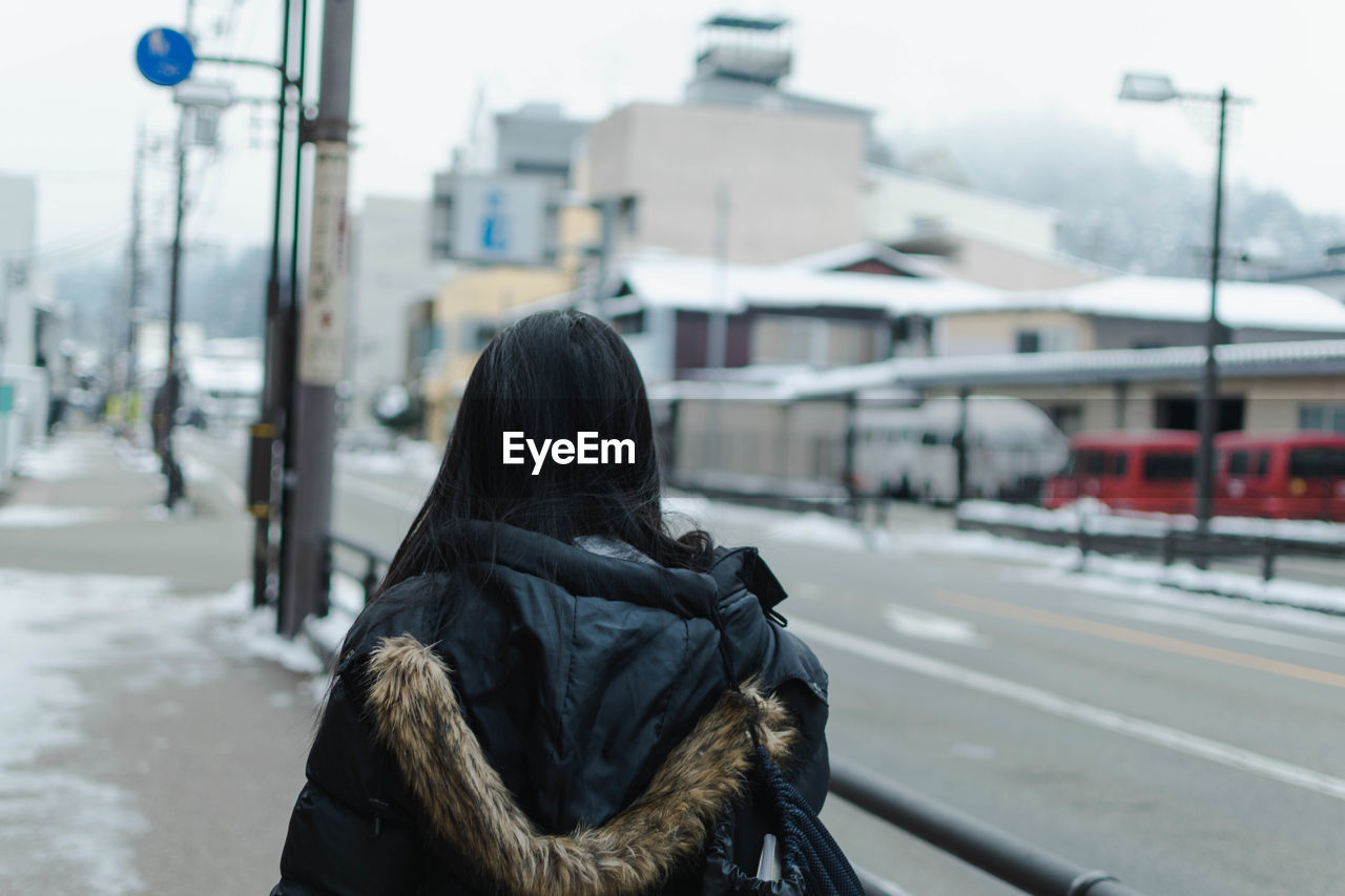Rear view of woman on street in winter