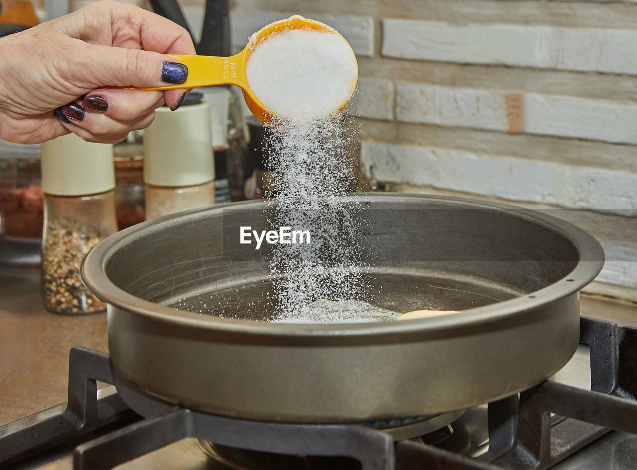 cropped hand of person pouring water in kitchen