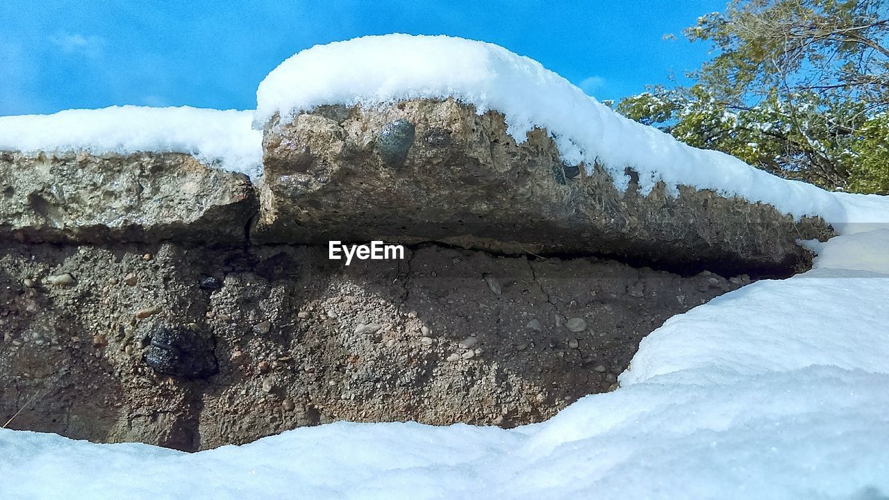 Snow covered rock formations against sky during winter