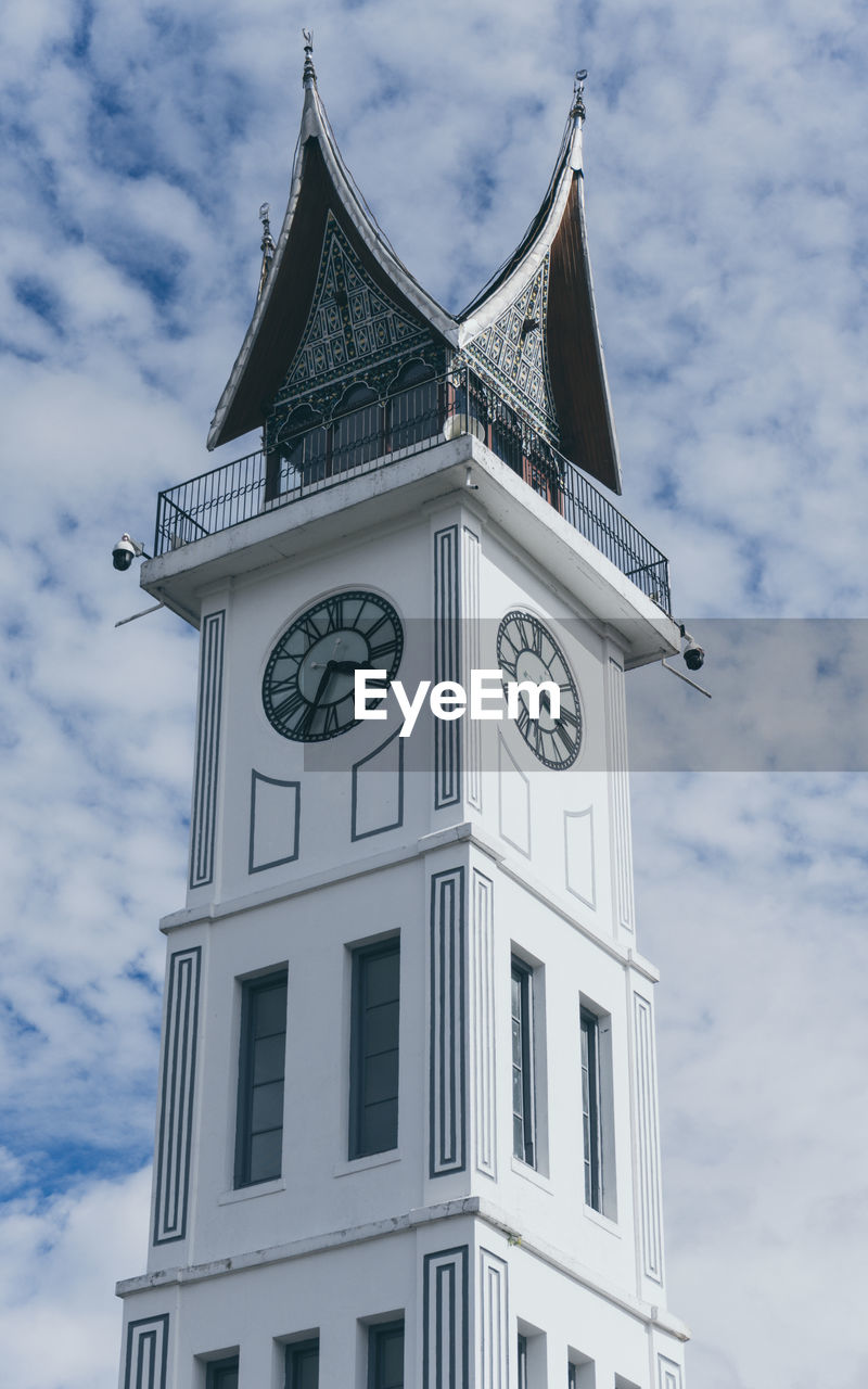 Low angle view of clock tower against sky, jam gadang.