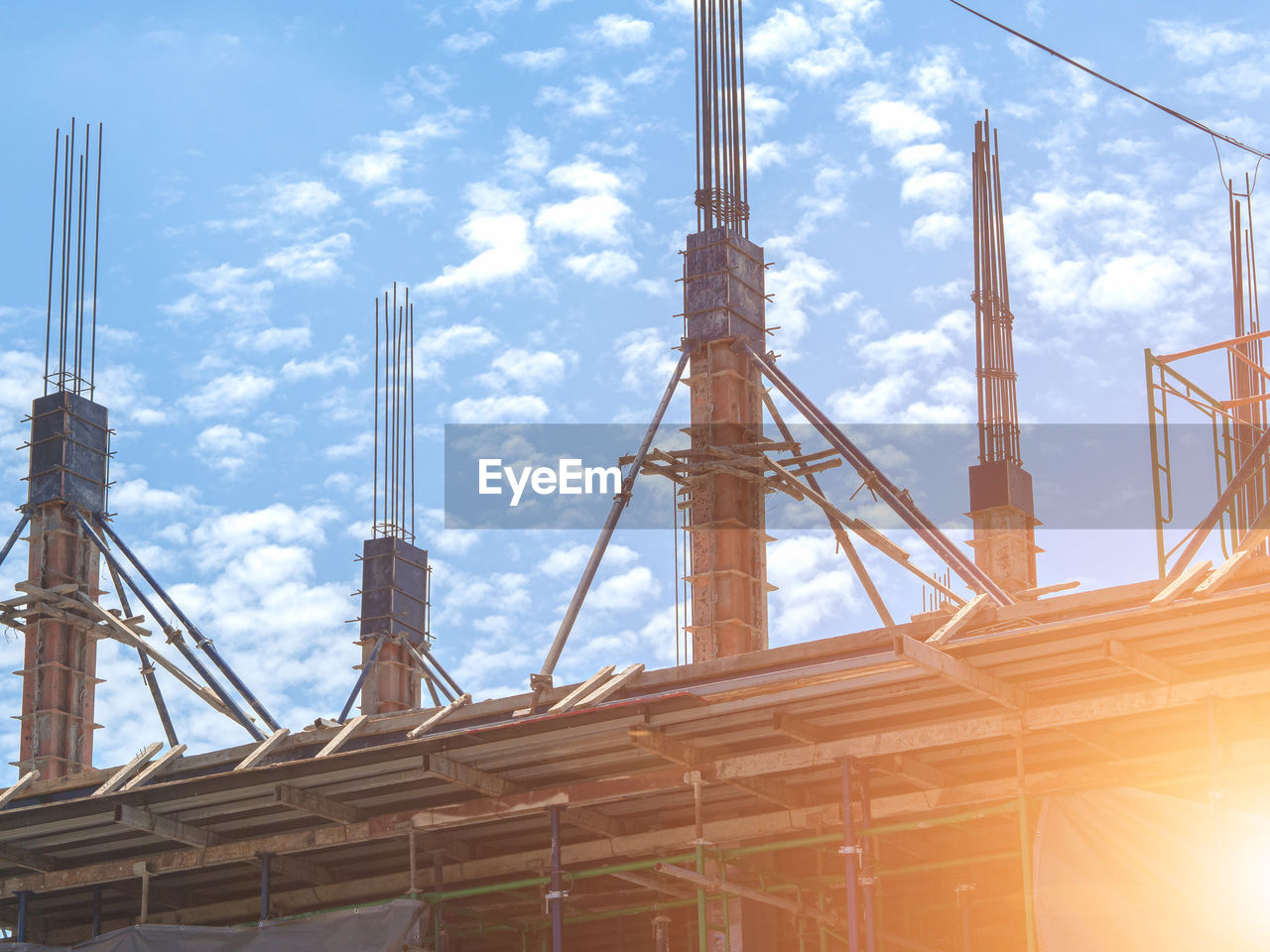 LOW ANGLE VIEW OF CRANES AT CONSTRUCTION SITE AGAINST SKY