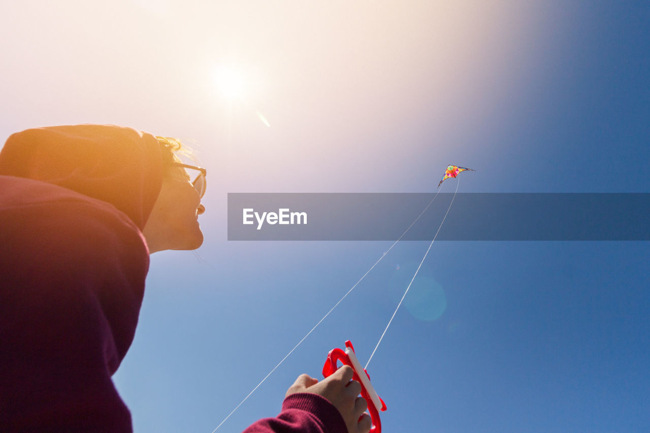 Low angle view of person flying kite against clear sky