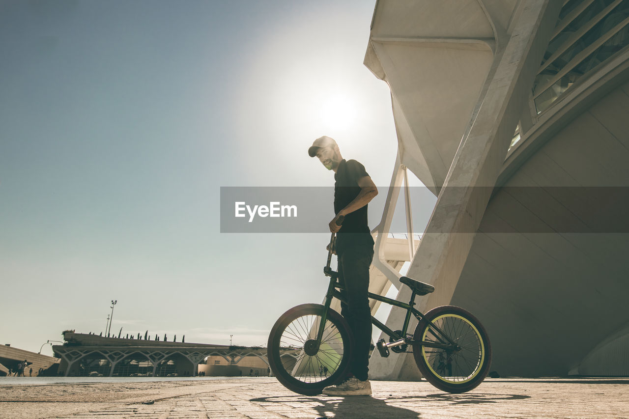 Man performing stunt on bicycle in city 