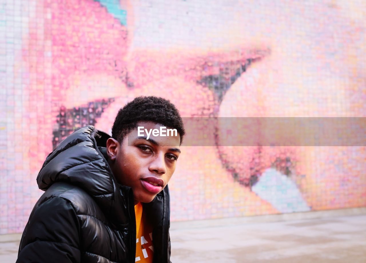 Portrait of young man against the kiss wall 