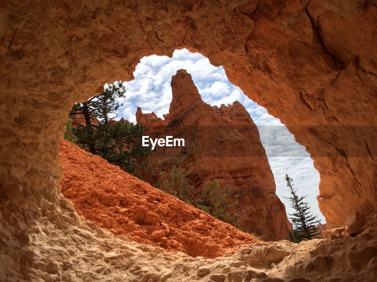 Scenic view of rock formation against sky seen through cave