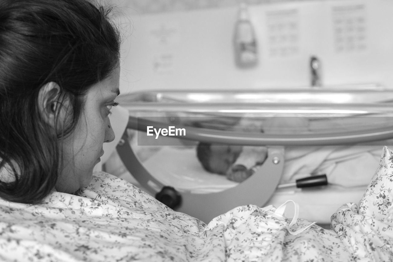 Mother looking at newborn baby at hospital