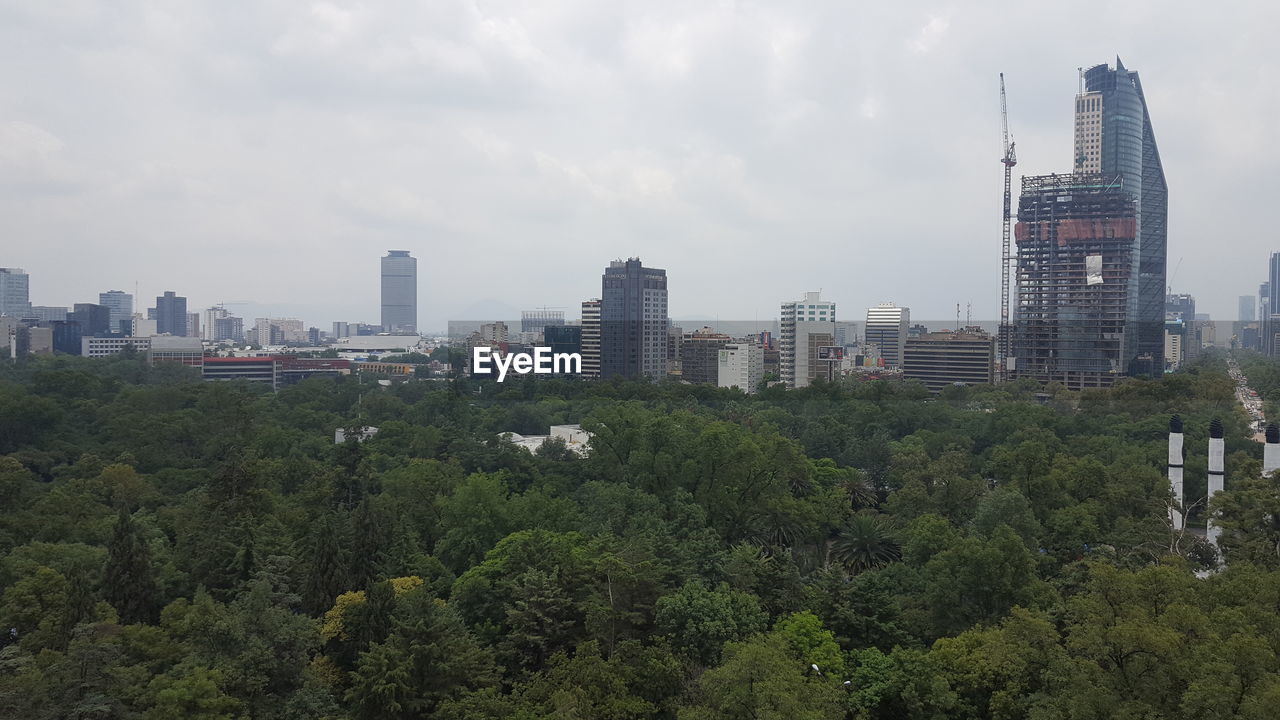 View of skyscrapers in city against cloudy sky