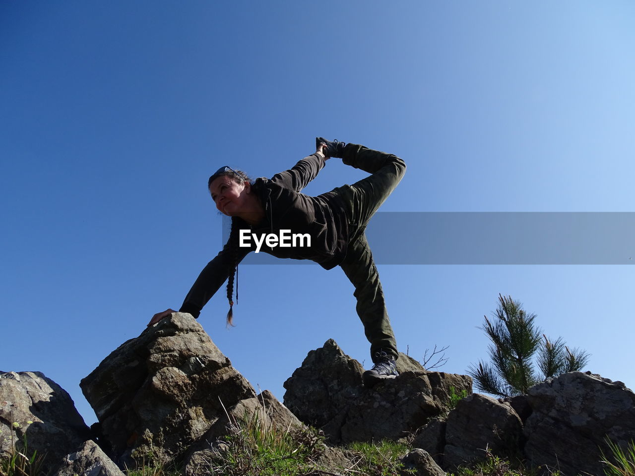 Woman ding yoga on mountain against clear sky