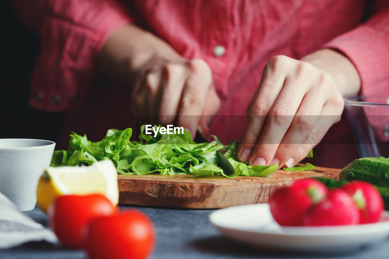 Midsection of woman cooking food at table