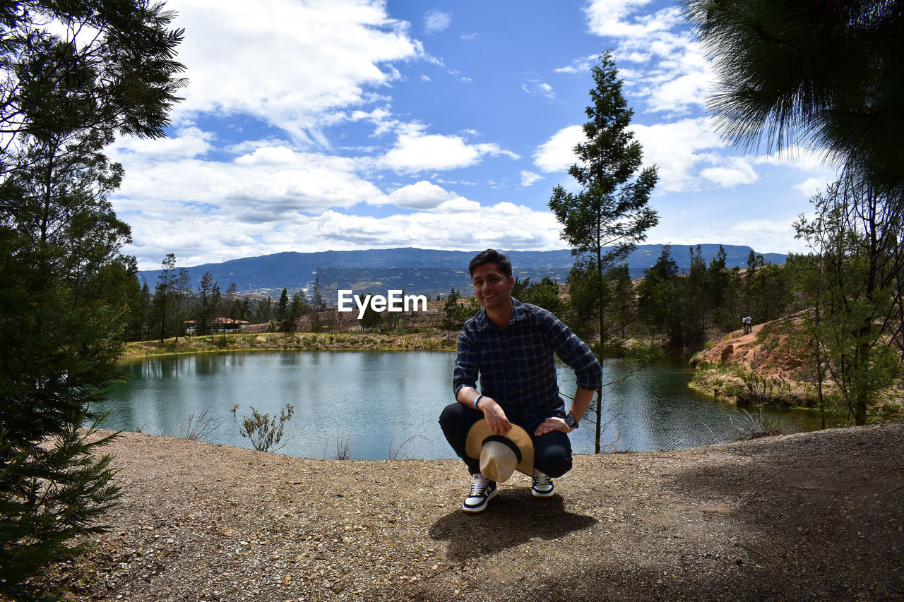 full length of man sitting on pier against sky