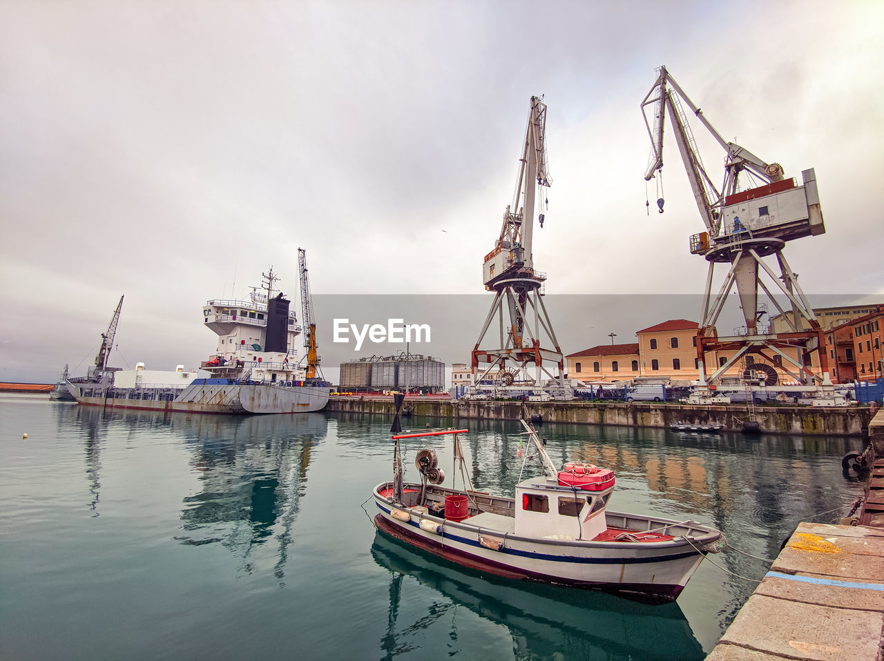 Italy, commercial port of imperia with fishing boats and ancient port cranes, liguria