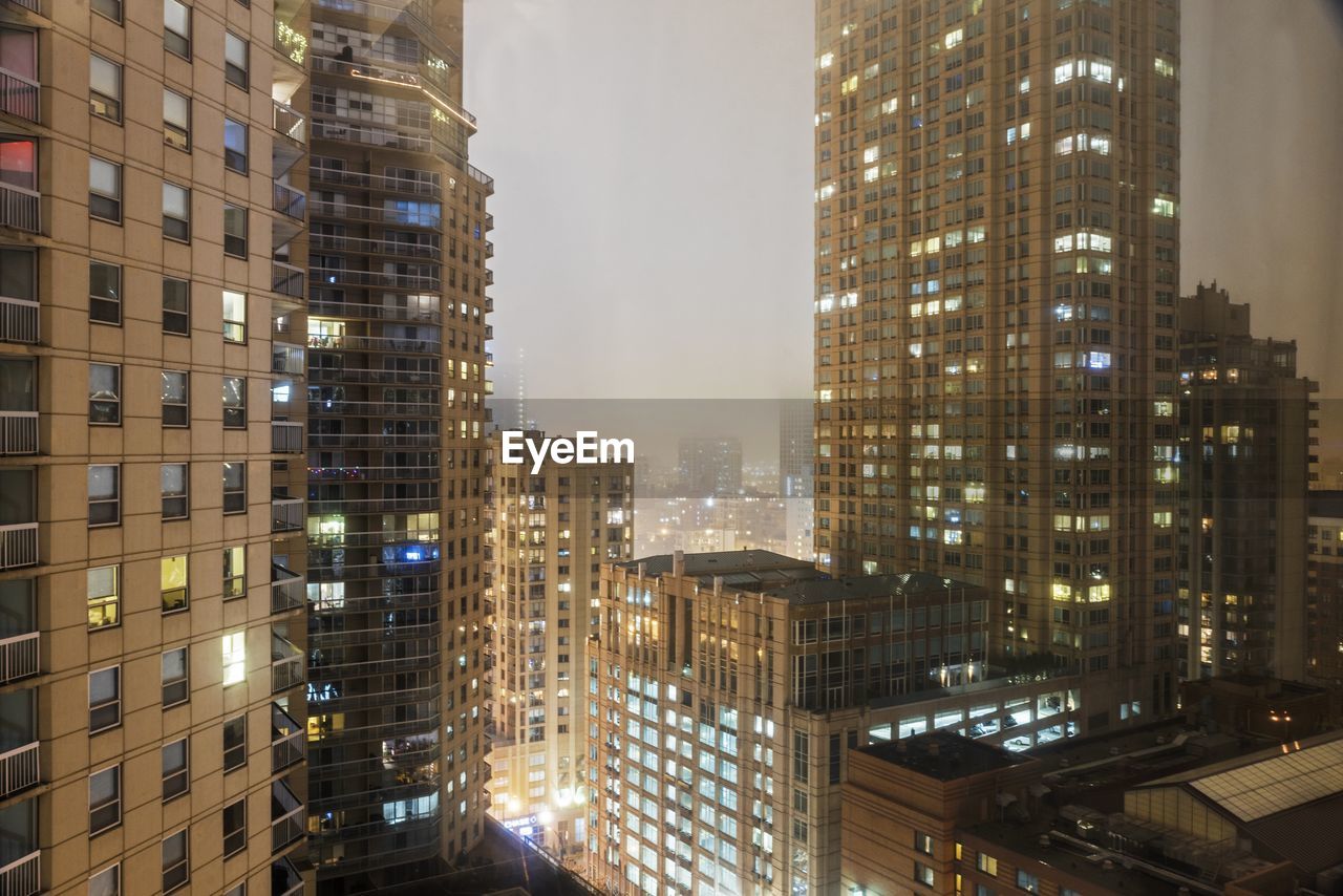 Illuminated cityscape against sky at night