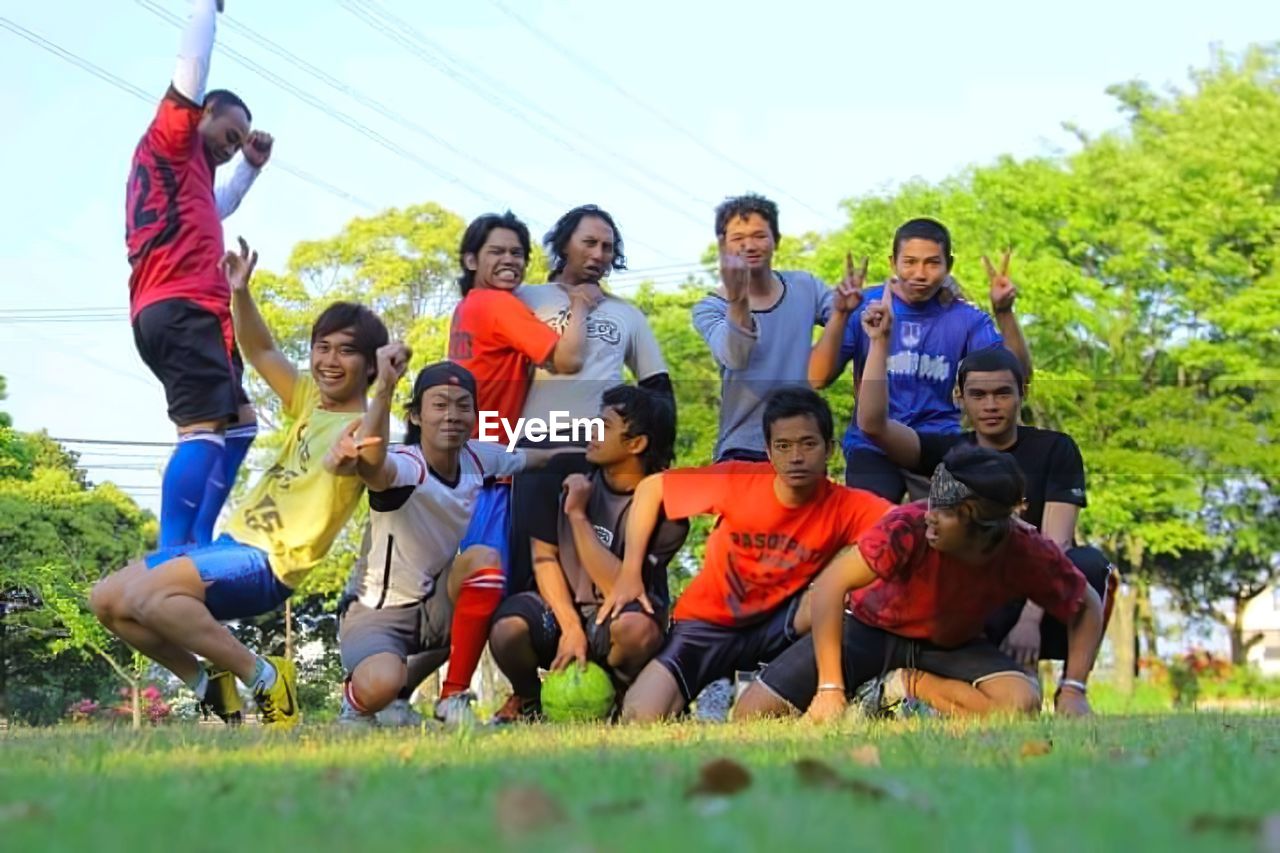 GROUP OF PEOPLE SITTING ON GRASS