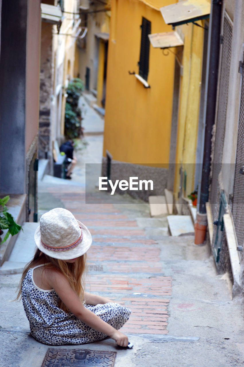 High angle view of girl sitting outside houses