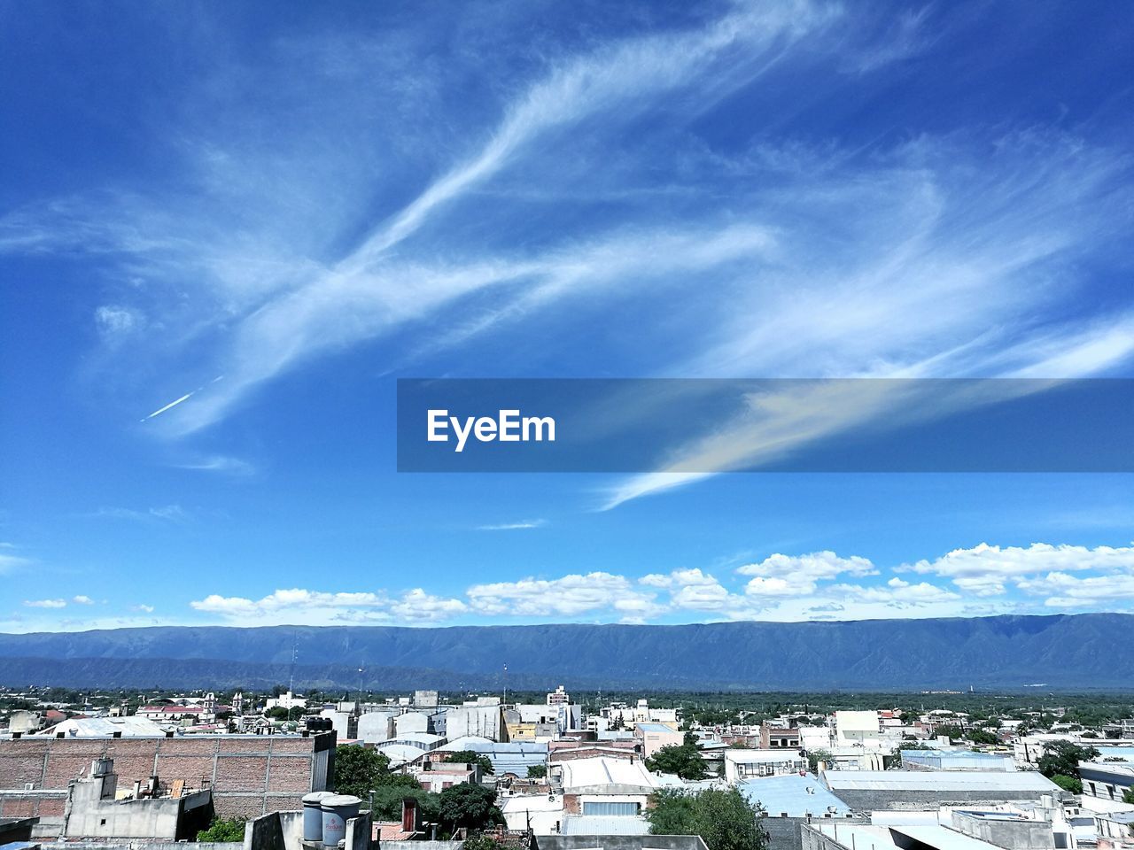 Panoramic view of cityscape against blue sky