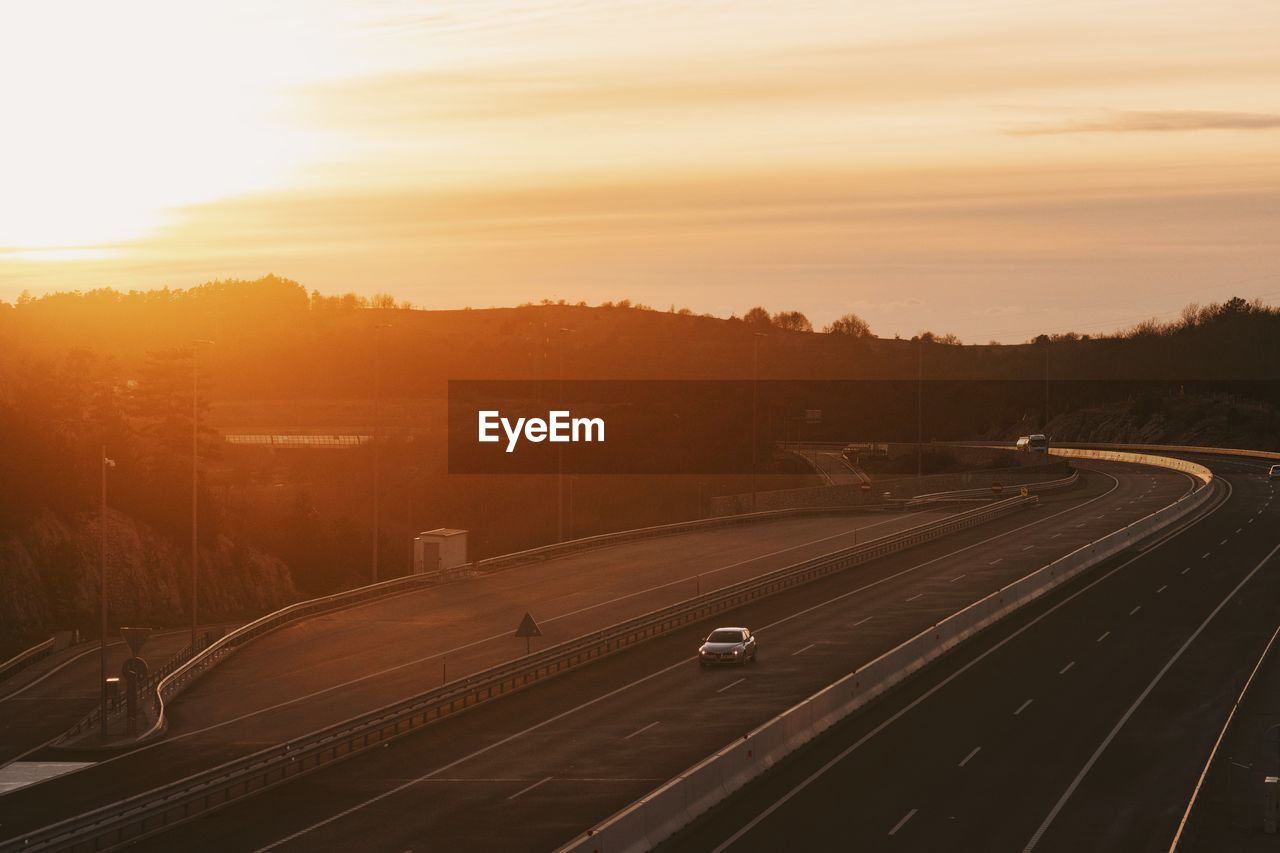 Aerial view of highway against sky during sunset