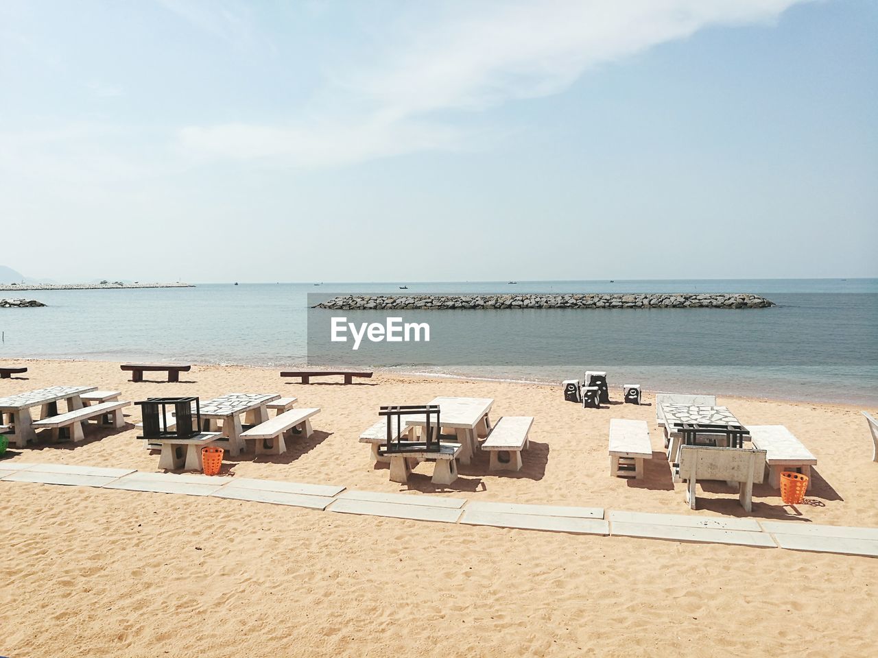 DECK CHAIRS ON BEACH AGAINST SKY