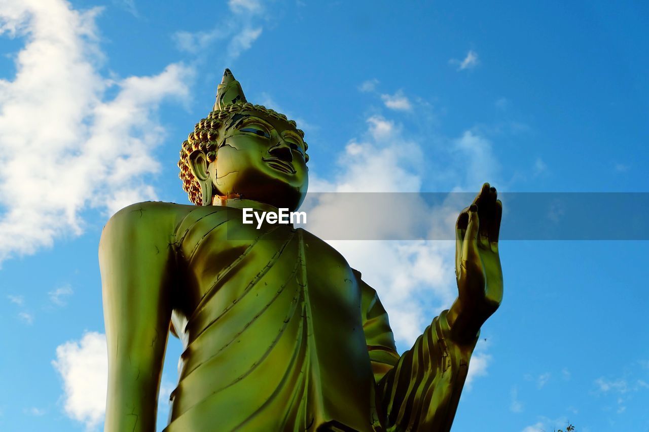 Low angle view of buddha statue against the sky