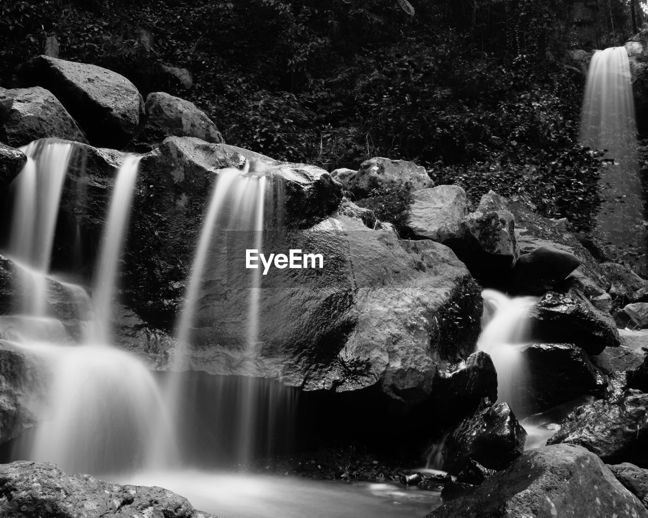 waterfall, water, scenics - nature, motion, water feature, beauty in nature, long exposure, rock, nature, black and white, monochrome photography, flowing water, environment, flowing, monochrome, blurred motion, land, forest, tree, body of water, stream, no people, splashing, plant, outdoors, river, non-urban scene, landscape, rock formation, travel destinations
