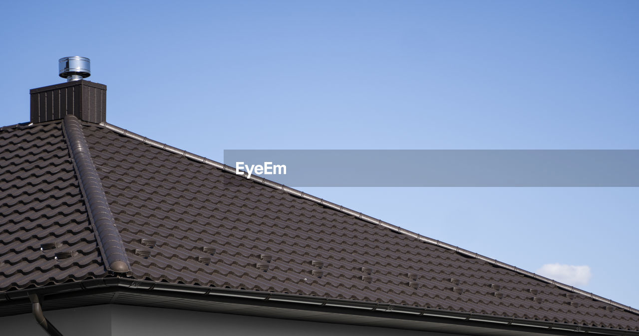 LOW ANGLE VIEW OF ROOF AND BUILDING AGAINST SKY