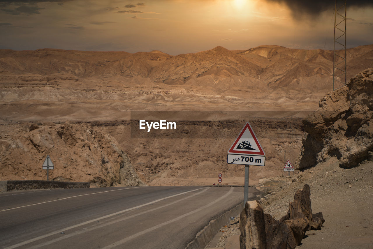 ROAD SIGN IN DESERT AGAINST SKY